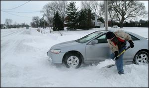 Perrysburg High School sophomore Conrad Seiling digs his car out of his driveway along Five Point Road.