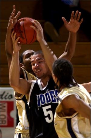 Charles Williams of Cleveland Rhodes is trapped by Brian Roberts, right, and B.J. Raymond of St. John's.