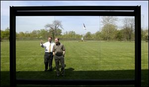 Stephen Weidner, left, vice president of sales and marketing, and David Strickler talk about newly developed anti-reflective glass at the Pilkington technology center in Northwood.