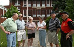 Sharing a laugh and reminiscing in front of the school building at Gomer are Darrell Frysinger, left, Elwood Thomas, Joann Thomas, Carla Olds, Tom Williams, and Jack Walls.