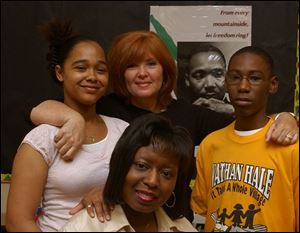 A poster of Martin Luther King looks over the shoulders of Nathan Hale teacher Pam Jackson with students Julia Randolph and Robert Easter, Jr. Social worker Trudie Neely is seated in front. 