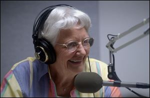 Volunteer Ethel Bradford reads the newspaper to listeners of the Sight Center Audio Network.