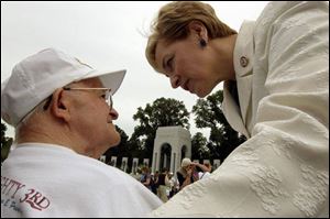 U.S. Rep. Marcy Kaptur congratulates World War II veteran and Toledoan Emmett Beavers II at the war memorial.