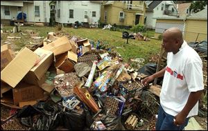 Roy Jenkins looks over debris produced by his Pearl Street neighbors' fireworks display July 4. The display reportedly lasted from sunset to sunrise.