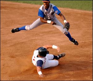 Durham shortstop B.J. Upton avoids sliding Mud Hen Guillermo Rodriguez and completes a double play.