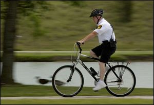 Patrolman Rick Baldwin of the Lake Township Police Department takes a new bike out for a spin in Friendship Park.