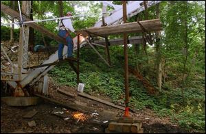 Jim Cook, a Toledo employee, cuts bolts on the arched channel of the Marengo Street Bridge.