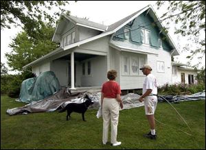 Jeanette Brandt, with Bob Koester of Spray On Siding, didn't want to cover the details of her 1920s-era bungalow. The thick liquid goes onto the exterior of a house much like traditional paint.