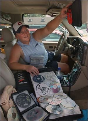 Meredith Duncan chooses one of the more than 500 CDs that she carries in her sport-utility vehicle on the LPGA Tour.
