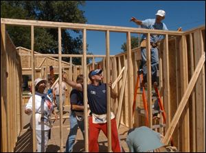 Alden Bodary, right, signals to Jason Lietaert to push the frame during construction of a Habitat house in Monroe.