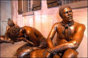 Life-sized bronze statues depict slaves waiting to be shipped to America.