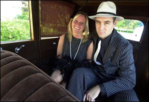 GANGSTA' WHEELS: Lisa Worthen and Paul DeRaedt 'go for a ride,' or at least pose in the back seat of a vintage auto at the Toledo Club.