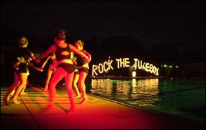 SPLASH DANCE: Girls, watched by proud parents, friends, and relatives, perform poolside for the audience at Toledo Country Club's water ballet.