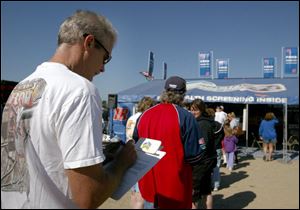 A NASCAR fan saves time by filling out a survey form as he waits in line for a free health screening at the GlaxoSmithKline facility yesterday at Michigan International Speedway.