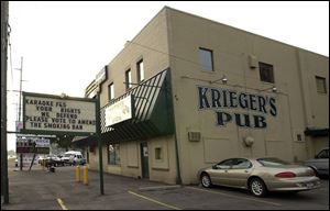 A sign outside Krieger's Pub on Laskey Road urges passers-by to take a stand against the existing Toledo smoking law and vote for a less-restrictive measure in November.