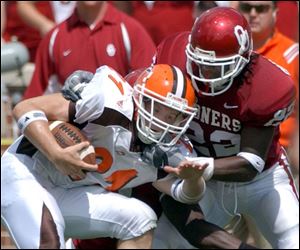 Bowling Green's Cole Magner, who made five catches, is wrapped up by Oklahoma's Chijoke Onyenegecha.