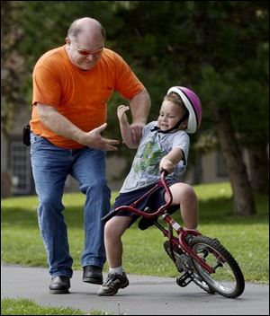 ROV September 15, 2004 - Tom Clapsaddle grabs the arm of his grandson Andrew Horton, 5, who started to fall while learning to ride a bicycle in Toledo's Walbridge Park Wednesday afternoon.  (Also helping but not in photo is Mary Clapsaddle, Andrew's grandmother and Tom's wife.)  Blade photo by Dave Zapotosky