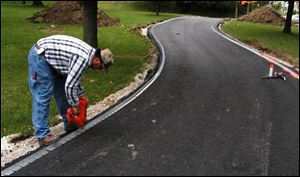 Nbr high08p .jpg David Stribrny nails edging on walkway at highland park. blade photo by herral long 9/8/2004