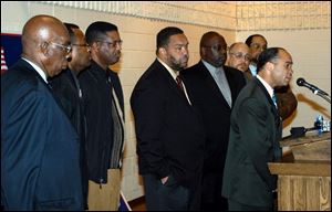 The Revs. John Roberts, left, Gerald Fletcher, and Benjamin Green; Mayor Jack Ford, and the Revs. W.L. Perryman, John Walthall, and Lee Williams listen to the Rev. Cedric Brock speak.