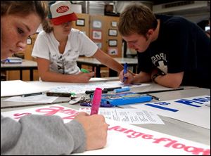 Cassey Outland, from left, Sharralyn Kauo-Schlegel and Justin Behrman make posters.