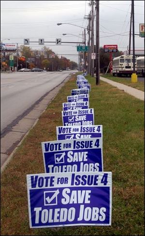 Signs along Heatherdowns Boulevard in front of Southwyck Lanes spell out the rationale for amending the smoking ban.