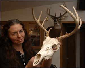 Jill Jurgess of Lenawee County shows off a young deer head. She has processed as many as eight road-kill deer in a year.