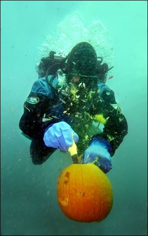 Divers such as Scott Lang of Fremont add another degree of difficulty to Halloween pumpkin-carving by wielding the knife 40 feet underwater in the Gibsonburg quarry. 