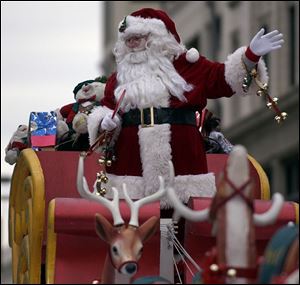 Santa Claus waves to spectators at the annual downtown holiday parade.