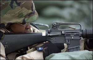 An M-16 shell casing is ejected as Spec. Sharon Stewart, 24, of Toledo takes part in a training exercise at Camp Atterbury.
