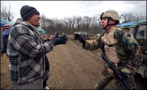 Iraqi native Raisan Al Shimray, shouts in Arabic at Sgt. Shane Sanderson during a simulation of a convoy attack. The exercise is designed to prepare soldiers for situations in Iraq. 