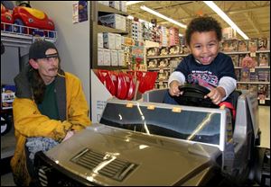 Mathias Jackson, almost 4, with his father, Michael Johnston, tried several vehicles before deciding he prefers the Hummer.