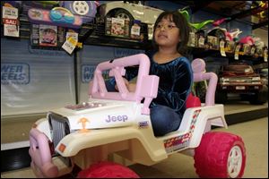 Jessica Gonzalez, 6, owner of an older model Barbie Jeep, is impressed by the  Jazzy Jeep Wrangler.