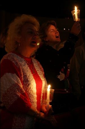 cty christmaseve24p 1 December 24, 2004. Left Betty Koprowski of Oregon, O., and her daughter-in-law Kim Koprowski of Luckey, O., sing 