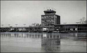 The image of the new airport terminal is reflected off the ice-coated tarmac on Jan. 5, 1955. The airport opened the following day.