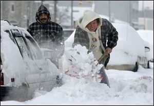 Rito Pizanna, left, takes a breather while Mary Lourdes Palacios battles the packed snow.