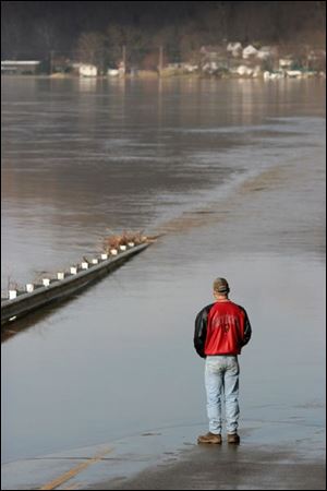 Bill Priddy examines a submerged road leading into Pomeroy. Almost all the roads in the area are under water.