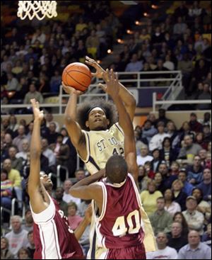 B.J. Raymond, who had 26 points, soars over Scott's Kenneth Byrd (40) and Rayshawn Maulsby.