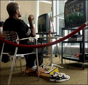 Mario Duncan plays video football with his feet at the Main Library in Toledo. 'I have a disability, so I can't go out and play easily,' he said. 'Video games, they give me a chance to play.'