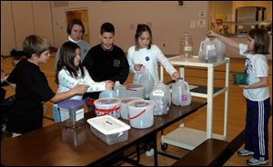 NBR coins21p   4th grade  students at Park Elementary School in Swanton try and decide which contaniner they are going to put their coins in. They are L to R Jacob Ervin age 9,  Kyrstin ( cq )  Terwilliger age 9,   D.J. Franklin age 10,  Jourdan ( cq )  Ramerez age 9,  Courtney Koback age 9,.  In the background is their teacher Sara Koralewski.    Friday 01/21/05 The Blade/Don Simmons