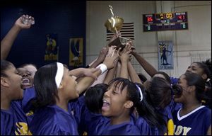 Waite's girls hold up the City League basketball championship trophy after defeating Notre Dame. It is the first time a public school has won the title since Macomber-Whitney in 1991.