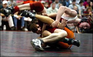 A.J. Scarberry tries to get out from under Arcadia's Lee Shumaker in the 112-pound championship match in the Division III district. Scarberry won with a reversal in the final 20 seconds.