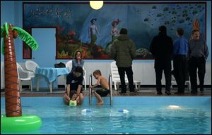 CTY mural25p Seagate Hotel guest Sarah Kennedy watches her husband, Derek Vaillant with their children, Janet, 3, and Ty, 5, play in the pool while a reception is being held for the TSA mural, Friday, Feb. 25, 2005. The Blade/Lori King