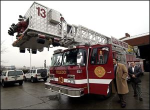 CTY firetruck28p A -- Toledo Mayor Jack Ford, left, and City Councilman Bob McClosky look at a new aerial ladder truck at the fire station at Consaul and Front streets in East Toledo during a press conference Monday, 02/28/05. The Blade/Andy Morrison