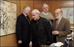 Father Gerald Robinson, center, is surrounded by attorneys,
from left, John Callahan, Henry Herschel, and Alan Konop,
after a press conference yesterday in Mr. Konop s offi ce.
