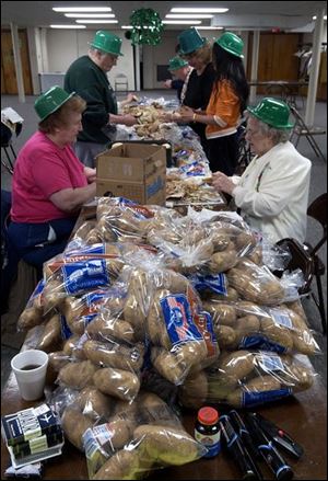 CTY peeling15p B -- Members of St. James Church, get ready for their St. Patrick's Day dinner, peeling potatoes, carrots and onions, as well as preparing the cabbage, Tuesday, 03/15/05. The Blade/Andy Morrison