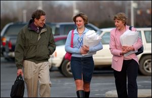 Dr. Tim Reichard, with his daughter, Brynne, center, and his wife, Sue, heads to the Toledo Zoo s guest services building, where he met with the zoo board of directors about his recent firing.