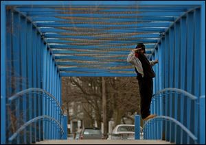 ROV trainspotting21p .jpg  Gregory Carter of south Toledo stands on the pedestrian overpass  over the railroad off of Emerald Avenue at Anthony Wayne Trail looking for trains 03/21/2005. The Blade/Lisa Dutton