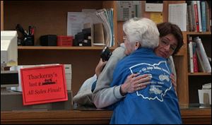 Thackeray s assistant manager Lee Post hugs longtime customer Cecilia Arras of Findlay on the bookstore s last day.