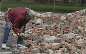 REG bricks12p 3 .jpg  Ron McNally looks over bricks from the former Lowell Elementary and Emerson Junior High School buildings in Fostoria, OH. He is looking for the bricks to give to his relatives and to use in his yard. The Blade/Lisa Dutton