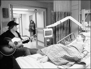 Gavin DeGraw, left, visits Nathan Watt, who suffers from spina bifida, at St. Vincent Mercy Medical Center. Mr. DeGraw said he will dedicate the song 'Shackles' in his concerts to the boy.